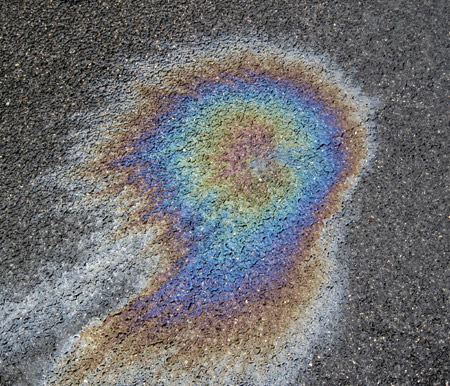 Gocce d'olio sull'asfalto bagnato